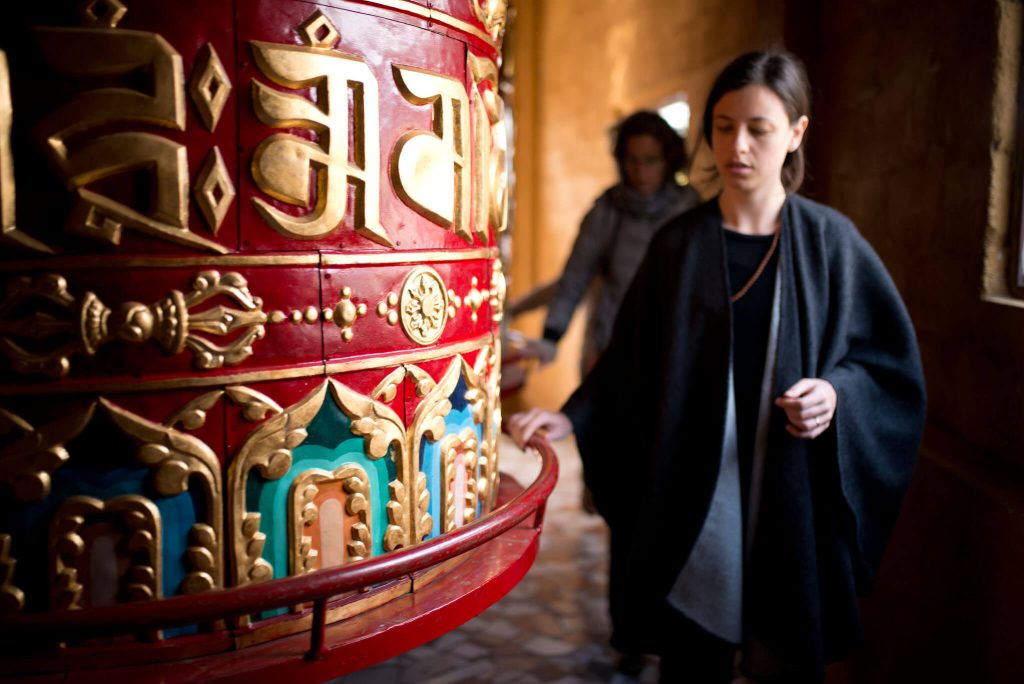 Students on Heather Elton's Yoga Teacher Training in Nepal spinning the giant prayer wheels at Neydo Monastery in Katmandu.