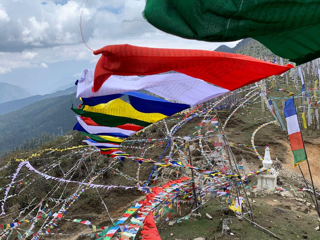 Students on the Bhutan Yoga adventure hanging prayer flags at 4000 m (about 13,000 feet) above Chela La Pass