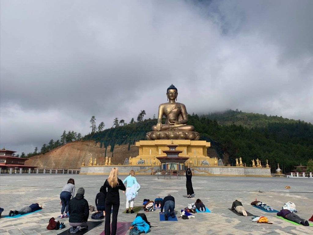 Students on the Elton Yoga Bhutan Yoga Adventure doing prostrations before the Buddha Dordenma.